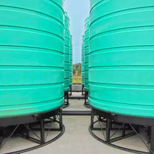 Cone bottom storage tanks on stands in a yard