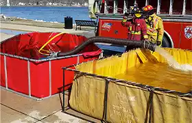 Two frame tanks being utilized by a firefighter as a water reservoir