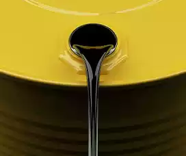 Oil pouring out of a yellow 55 gallon drum