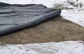Power heater blanket applied to snowy ground to thaw it