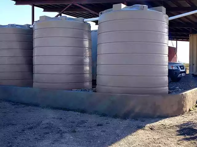 Three Poly tanks in series on a gravel pad