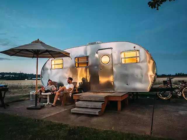 couple sittin in front of a camper